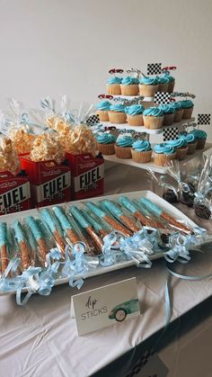 a table topped with lots of cupcakes and cookies