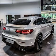 the rear end of a silver mercedes suv in a showroom