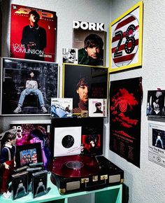 a room filled with posters and pictures on the wall next to a shelf full of records