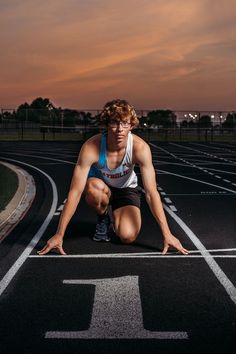 a man kneeling down on top of a race track