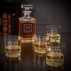 an assortment of whiskey glasses and a decanter on a table