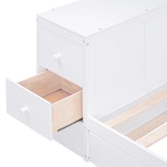 a white bed with two drawers on the bottom and one drawer open to show what's inside