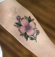 a woman's arm with a flower tattoo on it