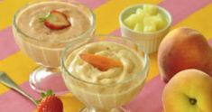 three glasses filled with fruit and pudding on top of a pink and yellow table cloth