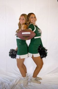 two women in cheerleader outfits holding a football