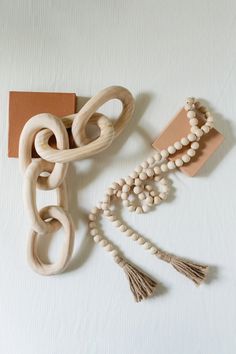 an assortment of wooden beads and necklaces on a white surface