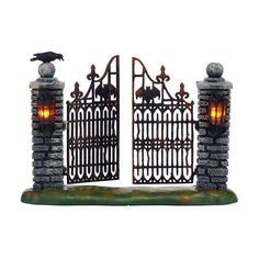 an iron gate with a bird sitting on it's top and the light at the end