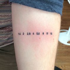 a person with a tattoo on their arm that has numbers written in black and white