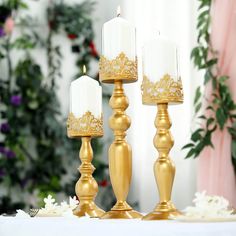 three gold candles are sitting on a table