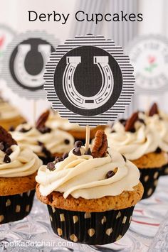 cupcakes with white frosting and chocolate chips on top sitting on a table