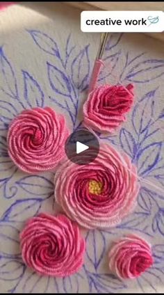 some pink flowers on a white plate with blue and purple designs in the middle, as well as a video about how to make them