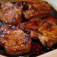 some meat is cooking in a pan with brown sauce on the top and bottom half