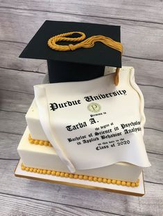 a graduation cake with a mortar and diploma on top