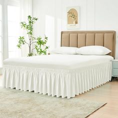 the bed is made with white sheets and ruffled bedskirt on it's headboard