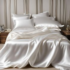 an unmade bed with white sheets and pillows