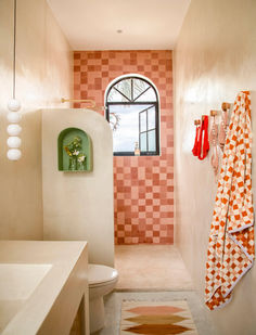 a bathroom with pink and orange tiles on the walls