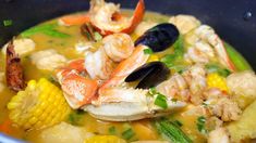 a bowl full of seafood and corn soup