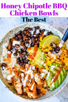 a bowl filled with rice, beans and avocado next to a lime wedge