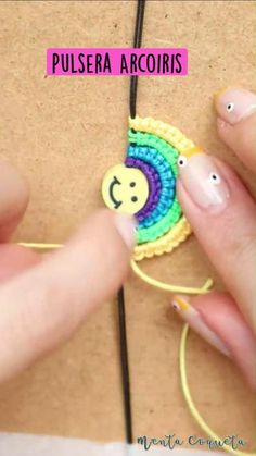 a person is making a smiley face brooch on a piece of string with the words pulsera acorisis