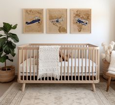 a baby crib with two paintings on the wall