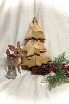 a small wooden christmas tree next to a silver ornament