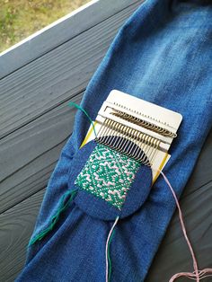 a pair of blue jeans sitting on top of a wooden floor next to a sewing machine