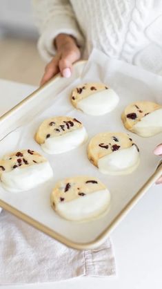 a person holding a tray with cookies on it