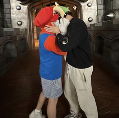 two people hugging each other in front of a castle entrance with an archway and clock on the wall