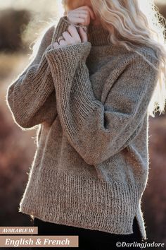 a blonde woman with long hair wearing a sweater and black pants is posing for the camera