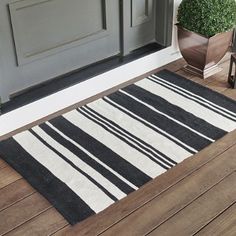 a black and white rug sitting on top of a wooden floor next to a door