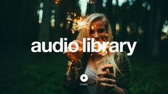 a woman holding sparklers in her hands with the words audio library on it