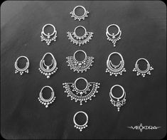 many different types of earrings on a black surface