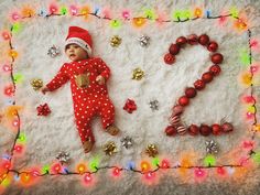 a baby is laying on a blanket with christmas decorations around him and his name spelled out