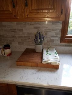 a wooden cutting board sitting on top of a kitchen counter