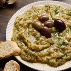 a white plate topped with olives and bread