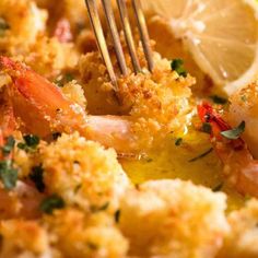 a close up of a plate of food with shrimp and lemons on the side