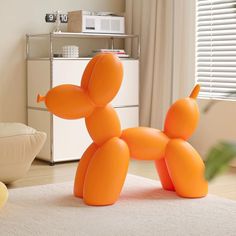 an orange balloon dog sitting on top of a white rug