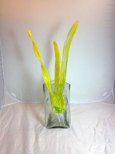 a glass vase with yellow flowers in it