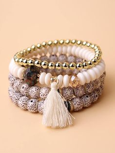 three bracelets with beads and tassels on top of each other, one beaded