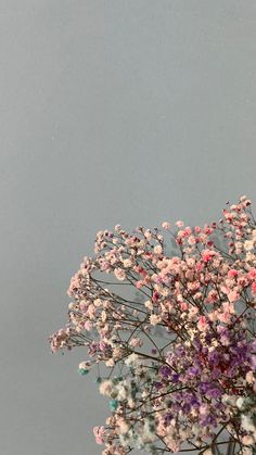 a vase filled with lots of pink and purple flowers