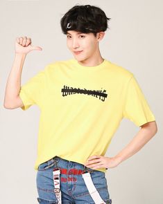 a young man in a yellow shirt is posing for the camera with his hand on his hip