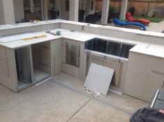 an outdoor kitchen being built in the middle of a backyard with construction materials on the ground