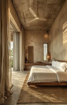 a bedroom with a large bed sitting next to a window on top of a wooden floor