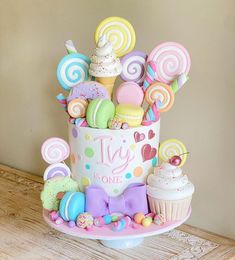 a birthday cake decorated with candies, lollipops and cupcakes