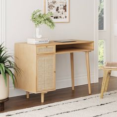 a wooden desk with a plant on top of it next to a chair and rug