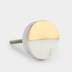 a white and gold door knob on a white background