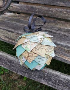 an origami globe sitting on top of a wooden bench