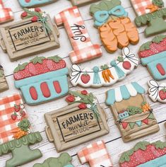 some decorated cookies are sitting on a white wooden table and there is a sign that says farmer's market