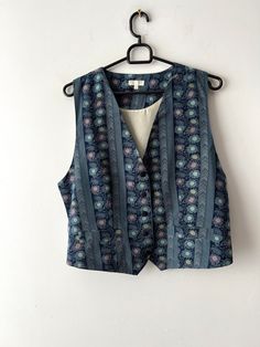 "Vintage Women's summer vest Blue Patterned silk vest Button Up Waistcoat Hippie Festival Vest Size medium to large Retro vest 90s silk vest Estimated size: M/L Measurements (lying flat): Length: 19.5\"/ 49.5 cm Pit to pit: 20\"/ 50.7 cm Waist: 19.5\"/ 49.5 cm Please check measurements to insure a proper fit. Remember to allow yourself some extra room for movement. You can compare these with something from your closet that fits you well. This vest will come to you freshly laundered and ready to wear. Please convo me if you need additional measurements. Condition: great Vintage Condition SHIPPING * I ship worldwide via Priority mail (Latvijas Pasts) from Latvia (EU). * I ship from Europe, so please allow 2 to 4 weeks for the package to arrive if you live overseas. * Europe 5 - 10 business d Fitted Silk Summer Vest, Bohemian Sleeveless Vest With Buttons, Vintage Blue Vest For Spring, Cheap Vintage Blue Vest, Vintage Blue Summer Vest, Blue Retro Cotton Denim Vest, Blue Vintage Denim Vest With Buttons, Assassin Costume, Vintage Denim Blue Cotton Vest