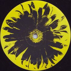 a yellow and black disk with an abstract flower design on the disc cover, in front of a black background